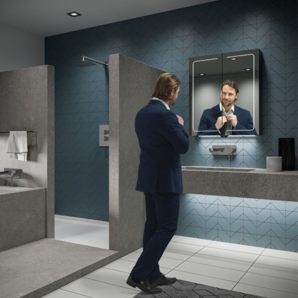 Lifestyle image of a man checking his reflection in the HIB Vapor 600mm LED Mirror Cabinet